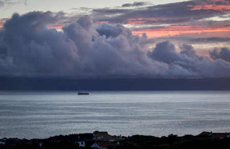 A boat on the sea under the sunset on the coast of Pico in the Azores