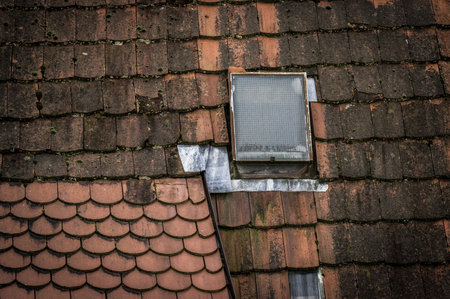 and a small glass window in the old red roof of the original houses of an ancient city