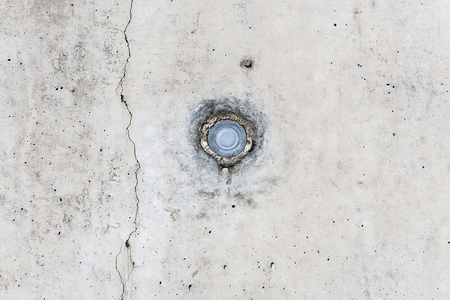 metal nail head embedded in white cracked wall - macro, backgroundの写真素材