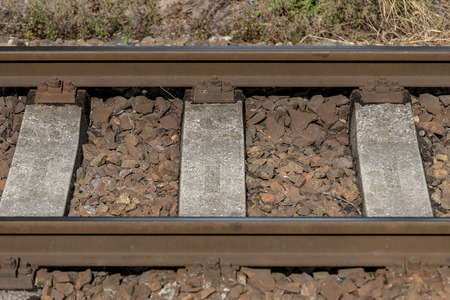 detail iron railings of the train between rocks in summerの写真素材