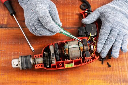 Technician repairs old electric drillの写真素材