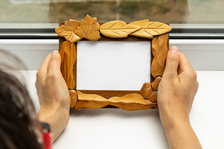 A woman holds a frame for photosの写真素材