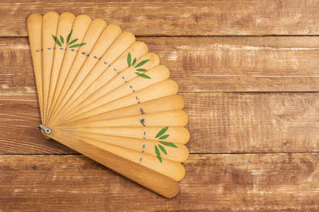An old wooden fan on a wooden background.の写真素材