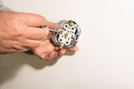 A man installs an electrical socket in the wall.の写真素材
