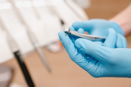Dental instrument in hand on a white background. Dental clinic hygiene. Two hands in blue gloves.