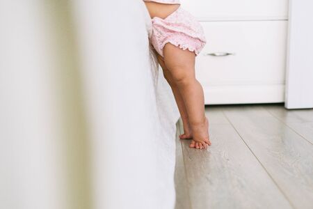 Little cute legs on the floor near bed at homeの写真素材