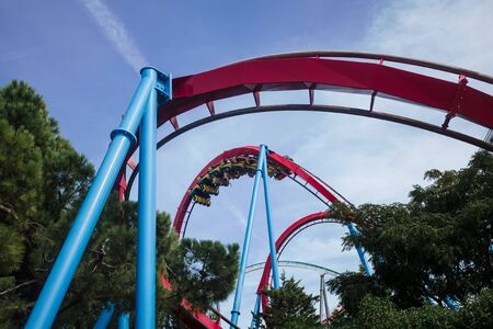 Attraction park. People ride a roller coaster in the park.の写真素材
