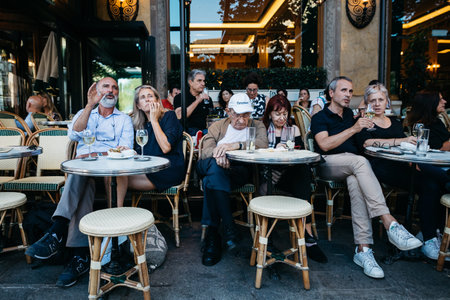 Paris, France. May, 2020. A lot of people sit on the street at tables in the restaurant and communicate.のeditorial素材