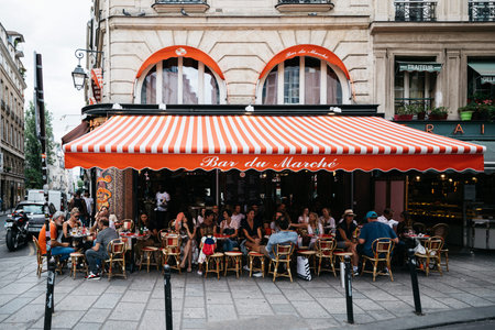 Paris, France. June, 2020. A lot of people sit on the street at tables in the restaurant and...