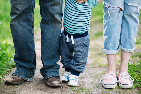 The legs of dads mom and little son. A family walk in nature.の写真素材