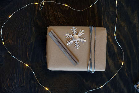 Christmas gift craft box with snowflake and garland. Yellow lights.の写真素材