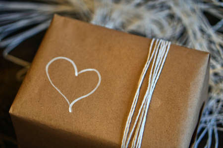 Gift with minimalist style wrapping design. White heart drawing on box.の写真素材