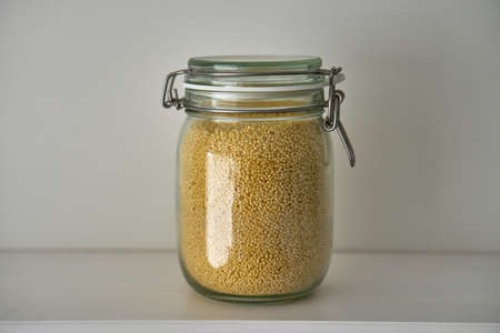 Glass jars with lid for food on a white shelf. Storage in kitchen. Containersの写真素材