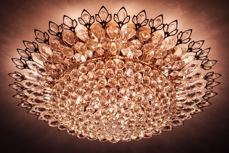 A crystal round chandelier is lit on the ceiling.