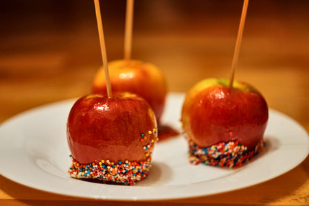 Christmas caramelized apples on plate. Delicious red candy topped with sprinkles