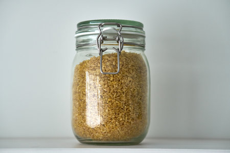 Glass jars with lid for food on a white shelf. Storage in kitchen. Containersの写真素材