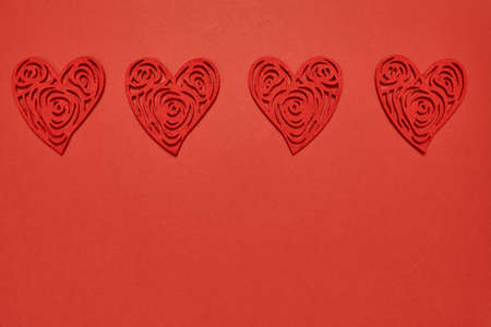 Red heart on a red background many. Monochrome with a symphol of love for a card and a gift for the holiday of saint valentine. Postcard card for a date and a wedding.の写真素材