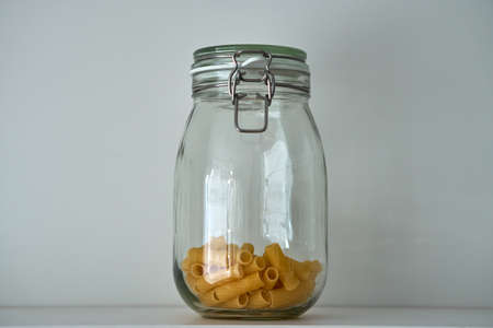 Glass jars with lid for food on a white shelf. Storage in kitchen. Containersの写真素材