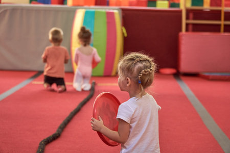 Girl gymnast goes in for sports. Red mats in the gym.の写真素材