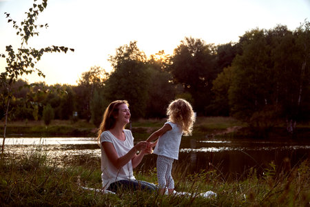 Mom and daughter on the street are looking at each other. Laughter and joyの写真素材