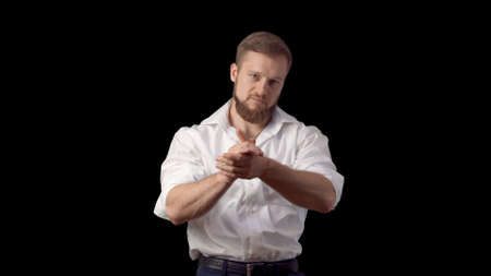 Applause. Bravo. A man in a shirt with a beard. Emotions. on black background.の写真素材
