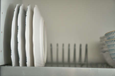 Dishes in the dryer. There are plates in the kitchen. White service. A drawer for dishes.の写真素材