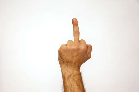 Middle finger gesture. Caucasian man holds his hand on a white background and place for text. Fuck you.の写真素材