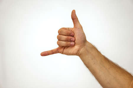 hang loose. Gesturing thumb and little finger. Hand of a Caucasian man on a white background. Place for textの写真素材