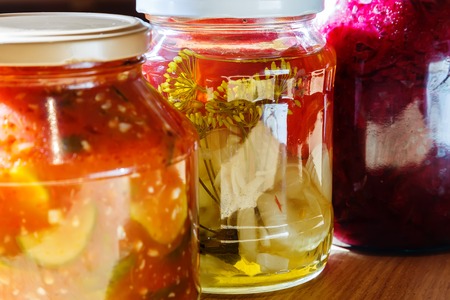 several jars of tinned vegetables on a wooden domestic tableの写真素材