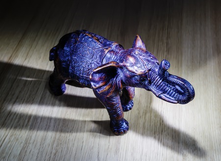 elephant figurine on wooden table simple low keyの写真素材