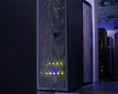 darkened room with rows of modern server hardware in data centerの写真素材
