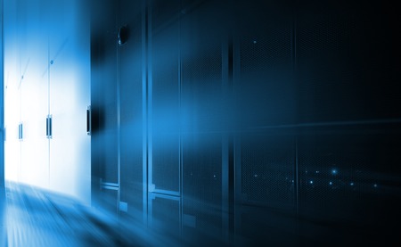 darkened room with rows of modern server hardware in data centerの写真素材