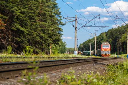 Electric train goes by rail, summer, countryside sunnyの写真素材