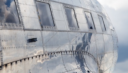 square windows of the old airplane sunny day reflection of the sky in aluminum casingの写真素材