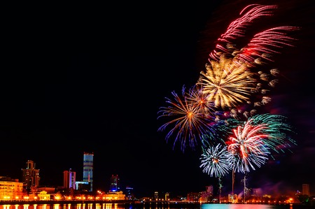 colored flashes of fireworks over the city pond of Yekaterinburg in city centerの写真素材
