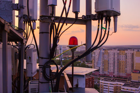 cellular communications tower on a background of the city and beautiful sunset in summer