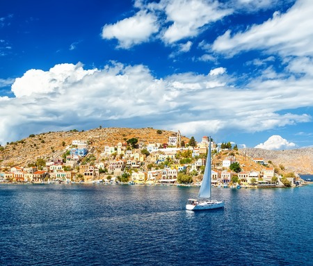 sailing yacht in the beautiful buildings of Symi , clouds, sky, bright Sunny dayの写真素材