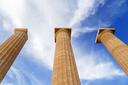 Three ancient greek pillars against a blue skyの写真素材