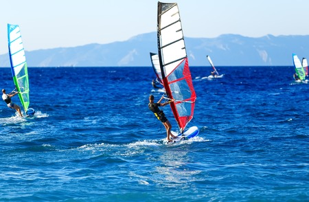 Side view of young windsurfer on background of other windsurfersの写真素材