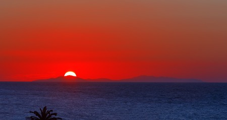 Nature background sunset or Sunrise over the mountains stones and the sea texture water above field meadow with dry yellow grass backdrop Empty copy space for inscription.の写真素材