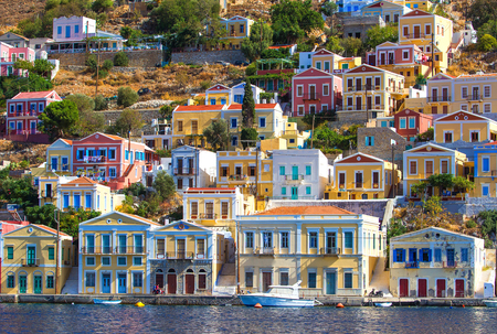 Greece. Dodecanesse. Island Symi Simi . Colorful houses on rocksの写真素材