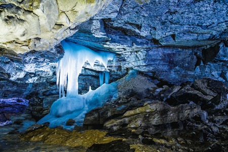 ice stalagmites in blue light fantastic in a beautiful cave with numerous mining depositsの写真素材