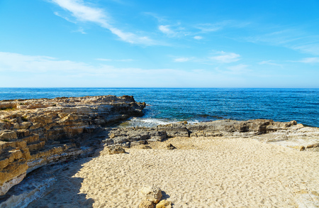 Volcanic rock on shore of island of Crete Greece, cloud sun weatherの写真素材