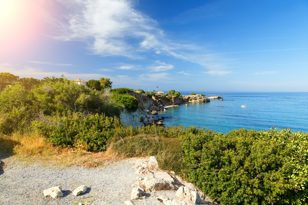 Greek holidays - Waves break on rocky shore. Coast and beach resort village. Road along a rocky cliff. Tourist beach resort in village Crete island, Greece.の写真素材