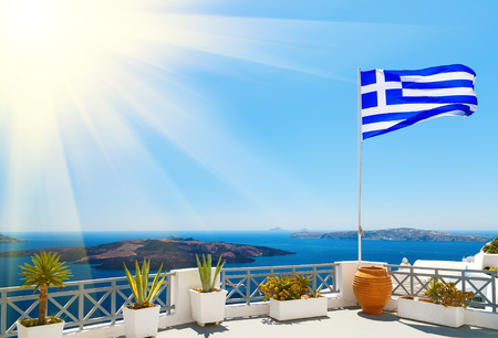 Greek flag waving at sunset in Oia, Santorini, Greeceの写真素材