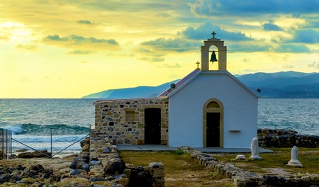Scenic landscape with white church and aegean sea at sunset, Crete, Greece.の写真素材