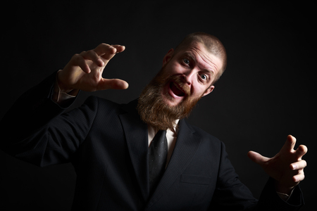 Crazy Funny face. Handsome businessman with beard and handlebar mustache looking at cameraの写真素材