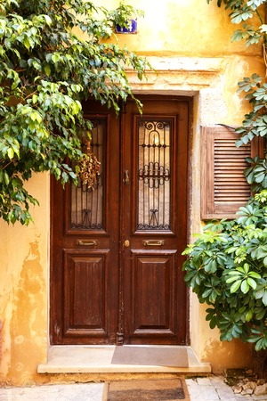 Beautiful ancient building with wood brown pictorial greek doors in Chania, Crete island, Greece.の写真素材