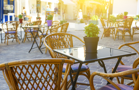 Pot with a flower in center of table on background of the Sunny city of Chania. tourists, Crete Greece. depth of field, blur Chania.Street Cafe.の写真素材