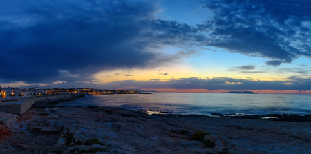 Nature in twilight period which including of sunrise over the sea and the nice beach in bay near Hersonissos, Crete island. Summer beach with blue water and purple sky at the sunset.の写真素材